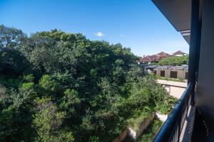 a view from a balcony of trees and houses at Zimbali Suites 617 in Ballito +3 photos