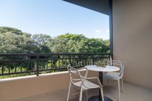 a balcony with a table and chairs and a large window at Zimbali Suites 617 in Ballito