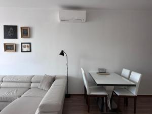 ein weißes Wohnzimmer mit einem weißen Sofa und einem Tisch in der Unterkunft Apartment near the Old Bridge in Petržalka