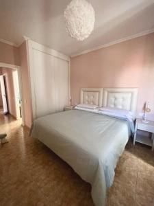 a bedroom with a large white bed with a chandelier at Ático Sun&Beach Fuerteventura in Gran Tarajal