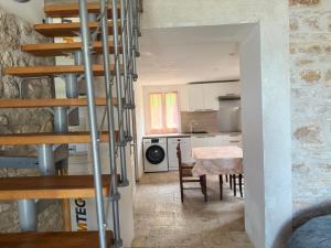 a kitchen and dining room with a spiral staircase at Bienvenue chez Weiwei in Sancé