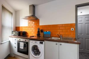 eine Küche mit einer Waschmaschine und einem Waschbecken in der Unterkunft Modern & Stylish 1 Bed Budget Apartment in Central Halifax in Halifax