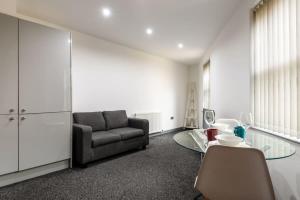 ein Wohnzimmer mit einer Couch und einem Glastisch in der Unterkunft Modern & Stylish 1 Bed Budget Apartment in Central Halifax in Halifax + 2 Fotos