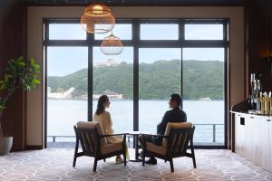 two people sitting at a table with a view of the water at TAOYA Nachikatsuura in Nachikatsuura