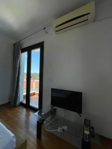 a living room with a tv and a glass table at BLUE HOUSE in Paliouri