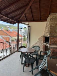 a balcony with a table and chairs and a fireplace at Family Hotel Studio in Sandanski +14 photos