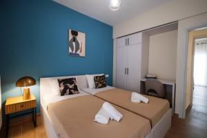 a bedroom with two beds and a blue wall at Aegean Nest I Seaside 3 bedroom Apartment in Alexandroupolis in Alexandroupoli