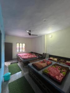 a room with two beds and green rugs in it at Devdarshan Hotel & Tourist Guest House Sonprayag in Jāmb