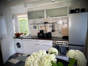 a kitchen with white cabinets and a washer and dryer at Tiny house with charm in Bremen