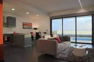 a living room with a couch and a kitchen at A&M House in Arco da Calheta