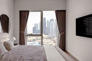 a bedroom with a large window with a view of a city at Burj Khalifa View Apartment in Dubai +36 photos