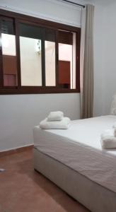a bedroom with a white bed with a window at Coastal Apartment in Cabo in Cabo Negro +10 photos