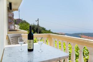 a bottle of wine and two glasses on a table at Apartment Dragicevic 3 with Garage in Budva +2 photos