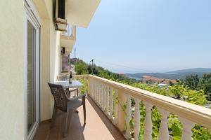 a balcony with a table and a chair and a view at Apartment Dragicevic 3 with Garage in Budva