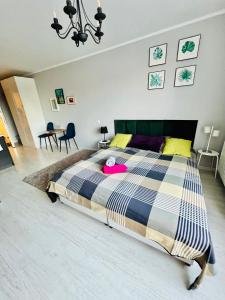 ein Schlafzimmer mit einem großen Bett mit einem rosa Hut darauf in der Unterkunft Charming studio Center of Krakow in Krakau