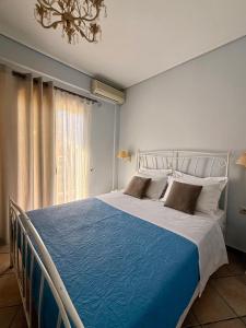 een slaapkamer met een groot bed met een blauwe deken bij Trizonia View Beach House - Glyfada Village by MPS in Glyfada Fokidas +32 foto's