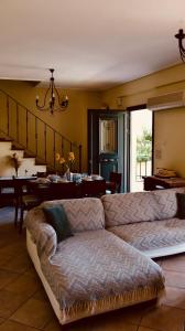 een woonkamer met een bank en een tafel bij Trizonia View Beach House - Glyfada Village by MPS in Glyfada Fokidas