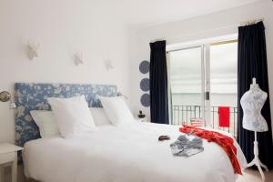 a bedroom with a large white bed and a window at The Strand Inn in Dunmore East