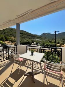 a white table and two chairs on a balcony at Maria's Rooms in Skala Rachoniou