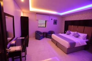 a purple room with a bed and a desk at Nova Park Serviced Apartments - نووا بارك للشقق المخدومة in Yanbu +37 photos
