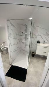a bathroom with a glass shower with a sink at LogisdesHalles in Béziers