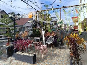 a patio with chairs and a fountain with plants at D'Hills Hotel in Bukittinggi