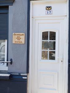 Una puerta blanca de una casa con un cartel. en Écrin de tranquillité, en Rosières-en-Santerre