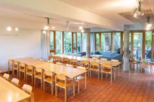 a dining room with tables and chairs and windows at Beinwil am See Youth Hostel in Beinwil