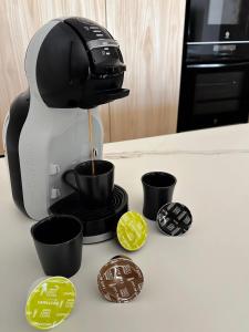 Una cafetera está vertiendo café en tazas en un mostrador en Luxury Apartament Free Parking, en Tomares