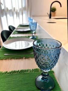 Una mesa con platos y un cuenco de cristal azul encima. en Luxury Apartament Free Parking, en Tomares