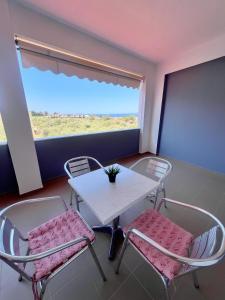 a table and chairs in a room with a window at Maria's Rooms in Skala Rachoniou