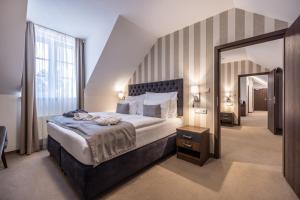 利普托斯基米库拉斯Wellness Hotel Demänová的一间带大床和大镜子的卧室 更多30张照片