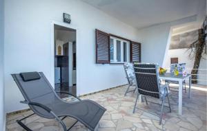 a living room with a table and chairs and a kitchen at Amazing Apartment In Kraljevica With Wifi in Kraljevica