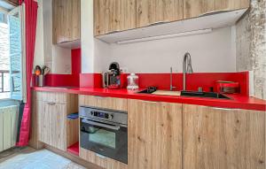 a red kitchen with a sink and a stove at Nice Home In Barjac With Wifi in Barjac +25 photos