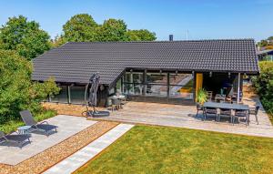 une maison avec un patio avec une table et des chaises dans l'établissement Awesome Home In Bindslev With Sauna, à Bindslev 33 autres photos