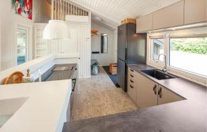 une cuisine avec un évier et un réfrigérateur dans l'établissement Awesome Home In Bindslev With Sauna, à Bindslev