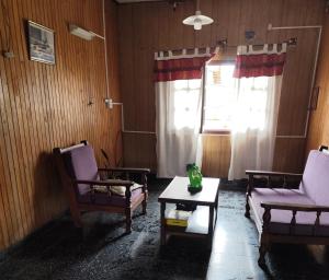 Una sala de estar con dos sillas y una mesa de café. en Hostal Orán, en San Ramón de la Nueva Orán