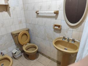 un baño con inodoro y lavabo en Hostal Orán, en San Ramón de la Nueva Orán