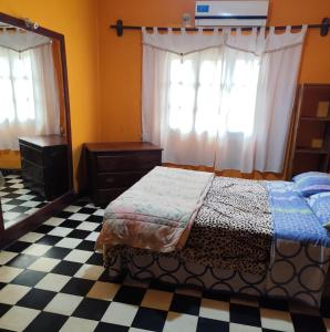 Un dormitorio con una cama, una cómoda y un espejo. en Hostal Orán, en San Ramón de la Nueva Orán