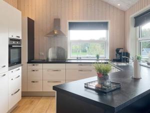 a kitchen with white cabinets and a black counter top at 4 star holiday home in Roslev in Roslev