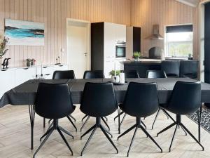 a dining room with a table and chairs in a kitchen at 4 star holiday home in Roslev in Roslev