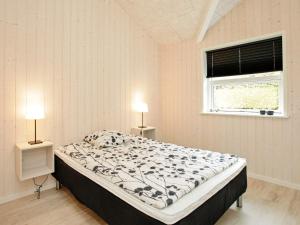 a bedroom with a bed and two lamps in it at 4 star holiday home in Roslev in Roslev