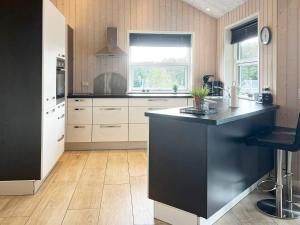 a kitchen with a black island in the middle at 4 star holiday home in Roslev in Roslev +33 photos