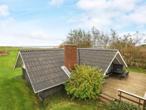 a house with a roof and a wooden deck at Seaside Rustic Retreat - By Traum Ferienwohnungen in Flovtrup +26 photos