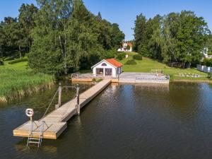a small house on a dock in the water at Villa Kolartorp in Ekolsund