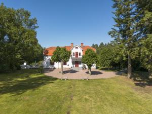 a large white house with a red roof at Villa Kolartorp in Ekolsund