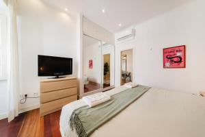a bedroom with a large bed and a television at Private Pool Chiado Gem, Patio Retreat wAC in Lisbon