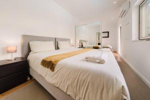 a bedroom with a large bed with a suitcase on it at Private Pool Chiado Gem, Patio Retreat wAC in Lisbon +59 photos