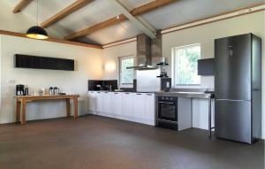 a large kitchen with white cabinets and stainless steel appliances at 3 Bedroom Lovely Home In Beesel in Beesel