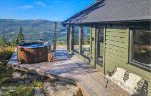 a green cabin with a hot tub on a deck at 5 Bedroom Stunning Home In Eggedal in Eggedal